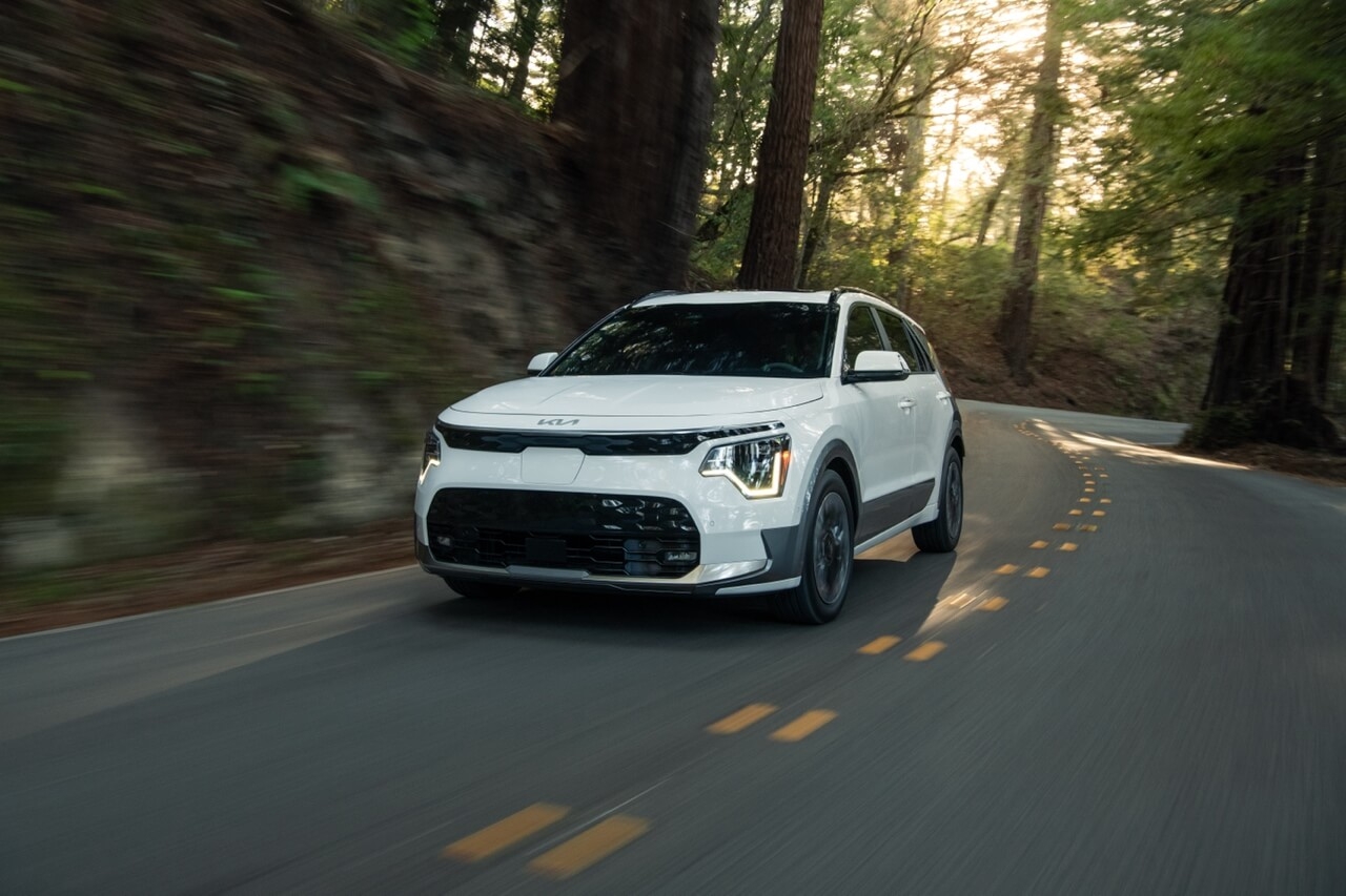 Le Kia Niro EV sur une route en forêt.